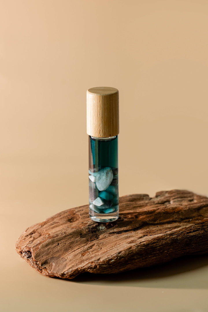 Small glass bottle with a wooden cap on a piece of wood against a beige background